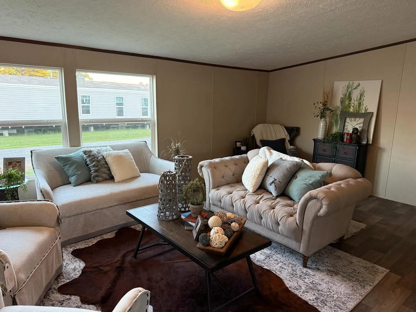 Staged living room with tufted sofa and cowhide rug